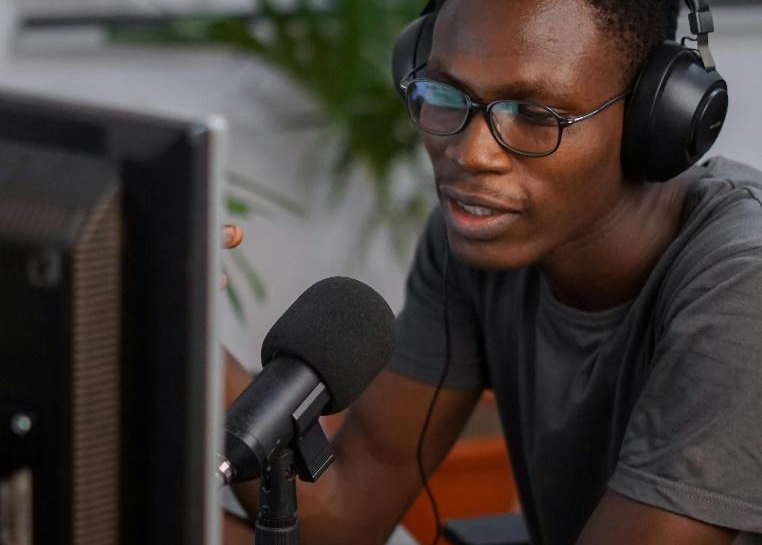 A man sitting at a table in front of a microphone, preparing for an interview