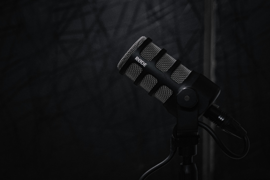 A close-up of a professional microphone on a stand against a dark background