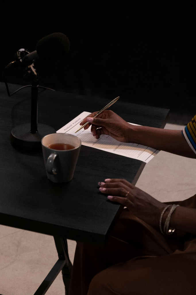 A person holding a pen and writing notes on a piece of paper.