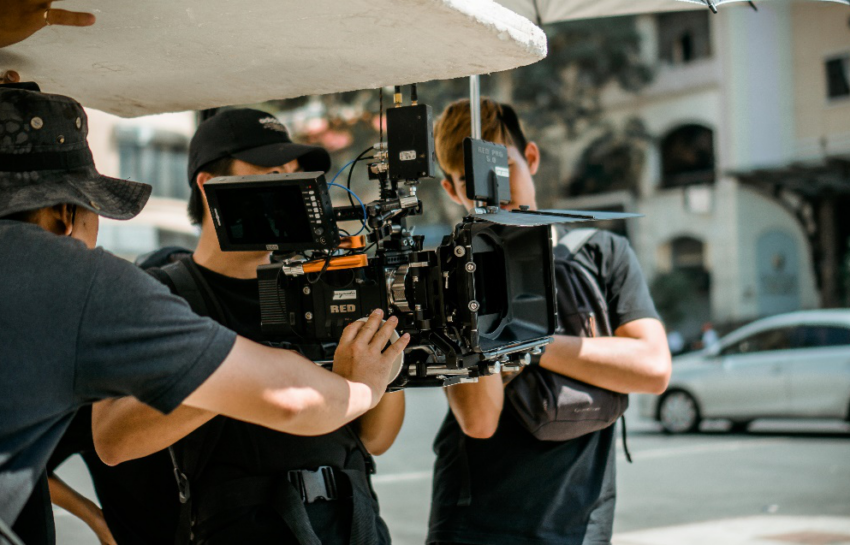 A person holding a professional camera, ready to shoot footage