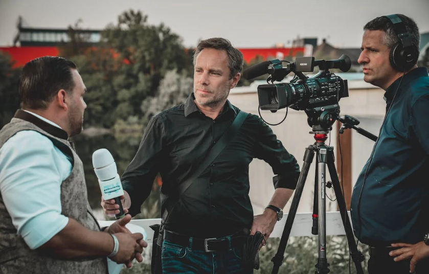 A cameraman and reporter interviewing a man