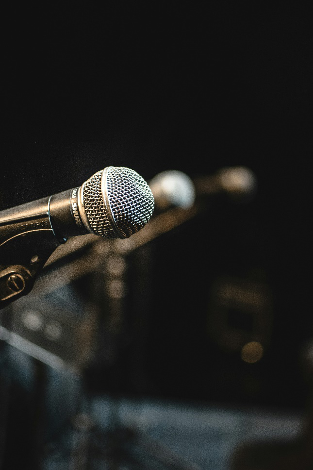 A close-up of a microphone on a stand, with a blurred background