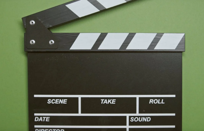 a clapper in front of a green screen