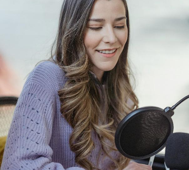 A woman speaking into a microphone during a podcast interview