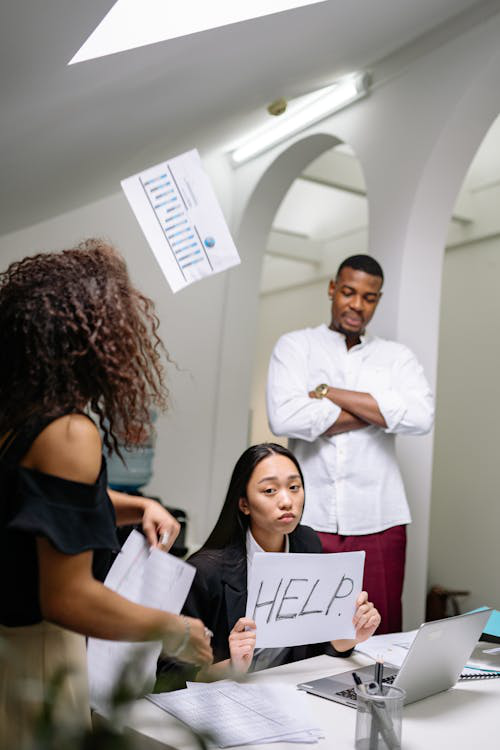 A bullied woman holding a paper with help sign