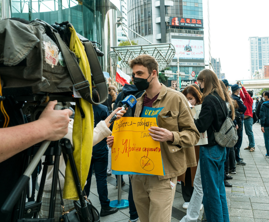 A young man talking to the press during a peaceful protest against war