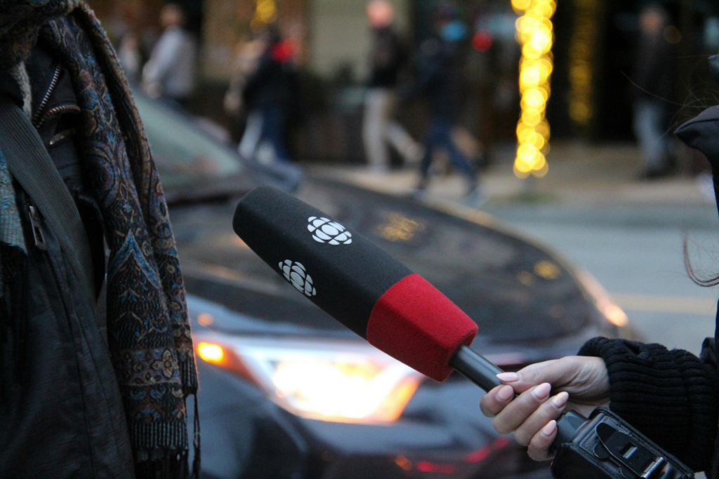 A person speaking and holding microphone