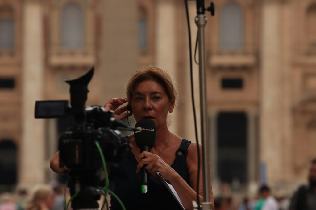 A woman in red shirt holding black microphone