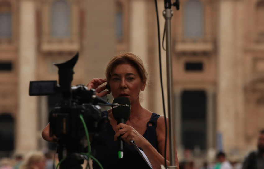 A woman in red shirt holding black microphone