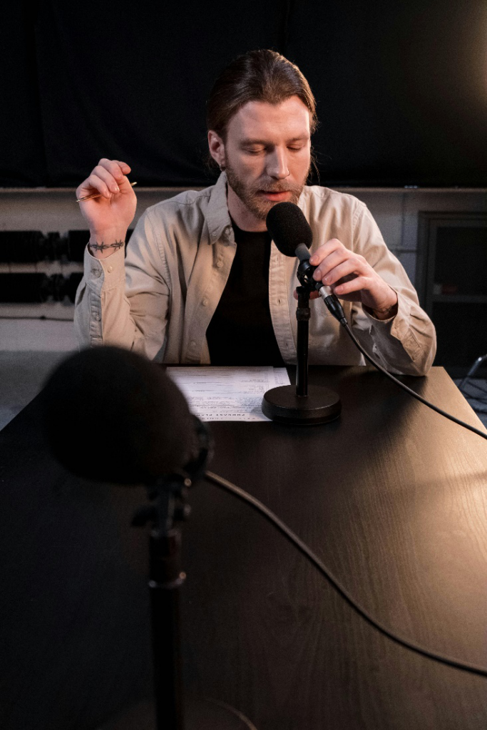 A man speaking into a podcast microphone