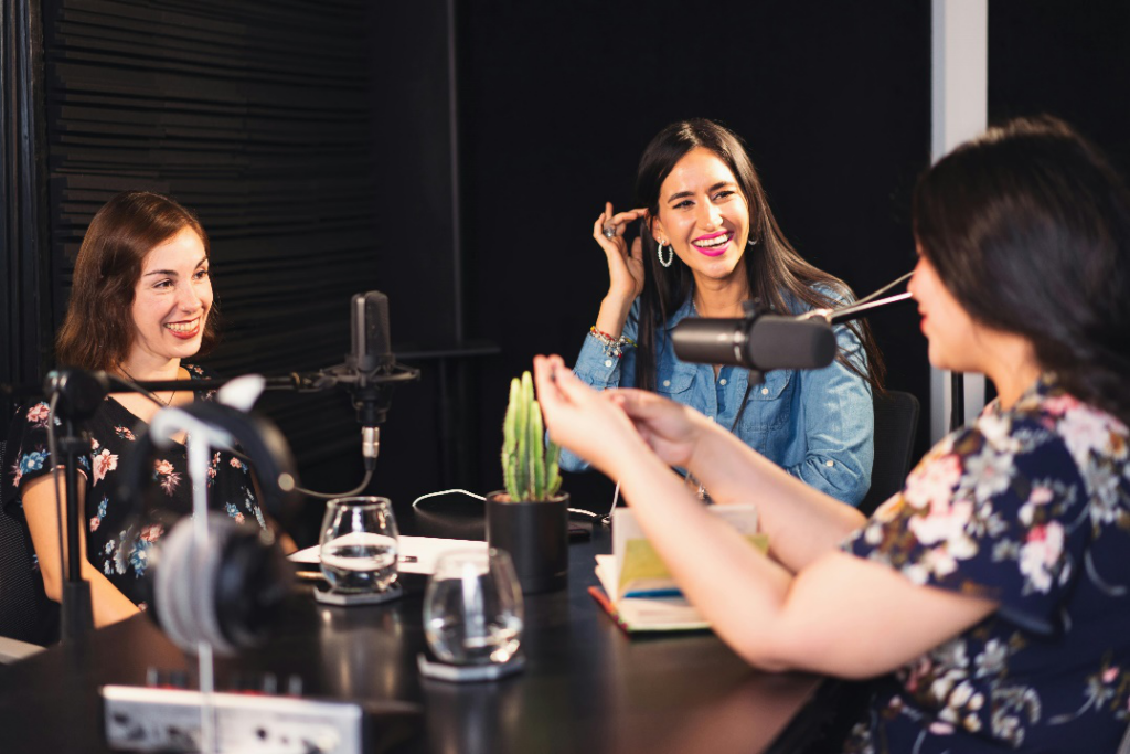 Three women engaging in a lively podcast discussion