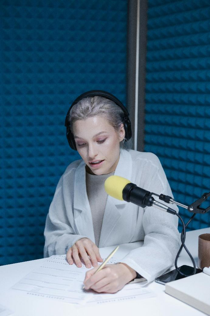 Woman speaking confidently into a microphone during a media interview, demonstrating how to handle tough questions with composure