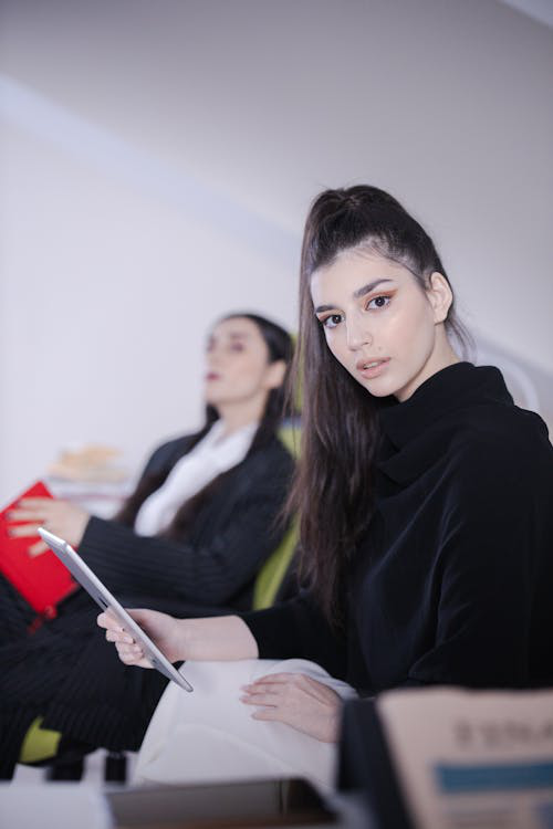 woman-in-black-long-sleeves-shirt-holding-a-white-tablet-computer