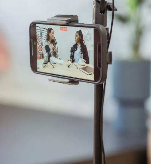 smartphone on tripod recording vlog with young multiethnic ladies