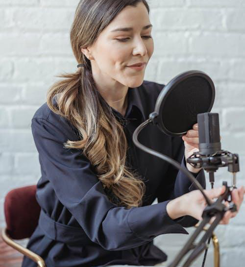 a smiling woman recording voice