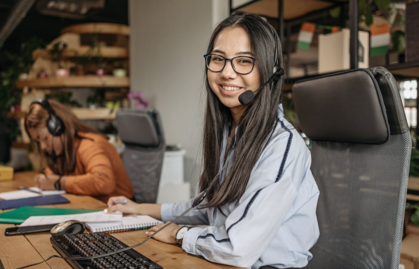 a woman smiling while sitting on her workspace