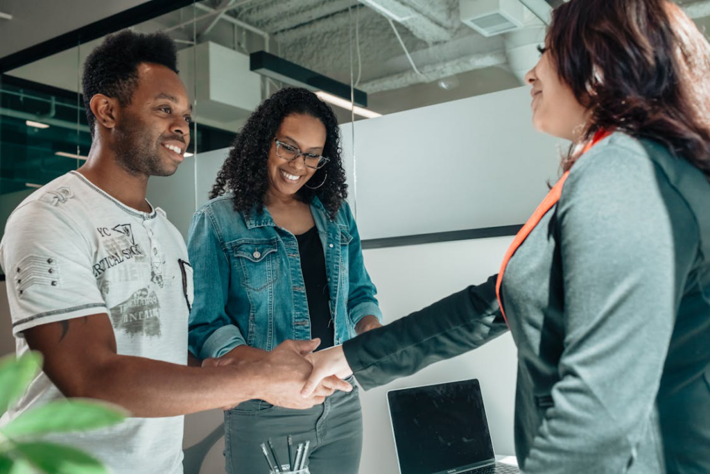 A couple shaking hands with an agent.