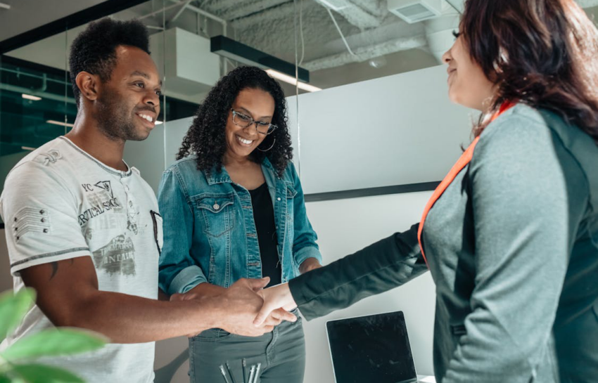 A couple shaking hands with an agent.
