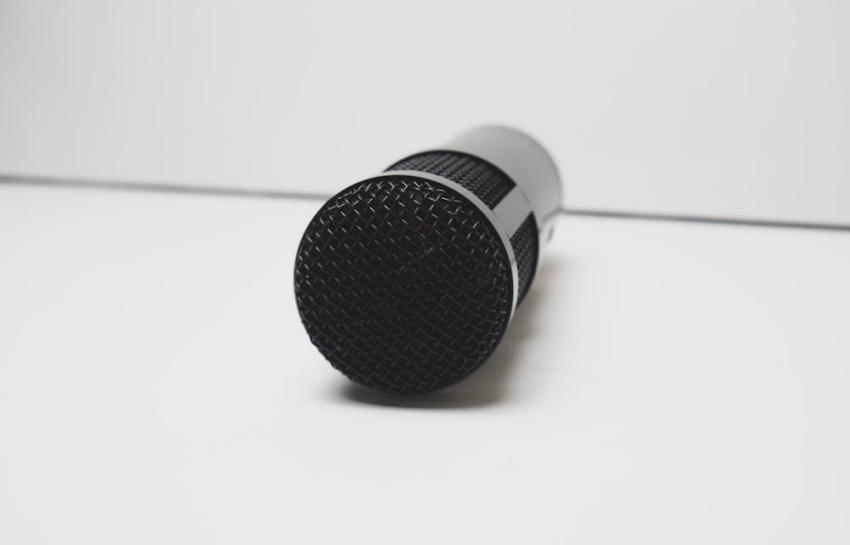 A black mic placed neatly on a white surface, capturing simplicity and focus.